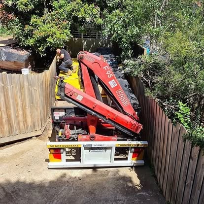 Crane truck delivering timber to site